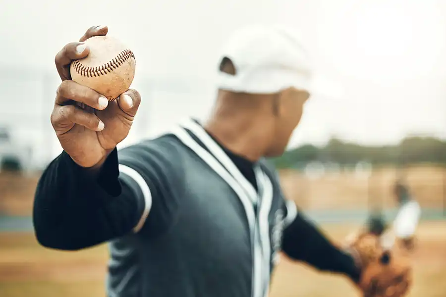 A baseball player throwing a ball on a baseball field after baseball and softball training classes at Darrah's All-Star Academy.